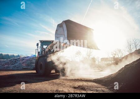 Bulldozer, der zur Kompostierung die Biomasse auf den Stapel legt Stockfoto