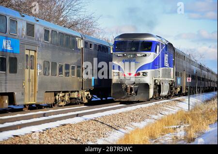 Bartlett, Illinois, USA. Metra Pendlerzüge fahren an einem sonnigen, aber kalten Winternachmittag in Bartlett, Illinois. Stockfoto