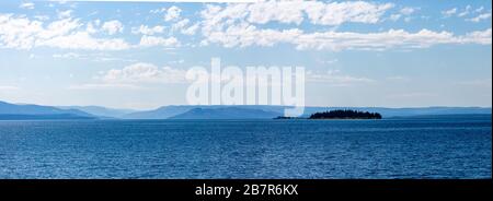 Yellowstone Lake mit einer Insel vor den Bergen im Yellowstone National Park im August, Panoramaaussicht Stockfoto