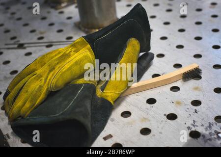 Ein Paar Schweißhandschuhe und Drahtbürste. Stockfoto