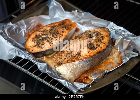 Steaks für Ofenlachs. Zwei rote Scheiben roter Fisch mit Gewürzen. Zu Hause gekochter Fisch zum Abendessen Stockfoto