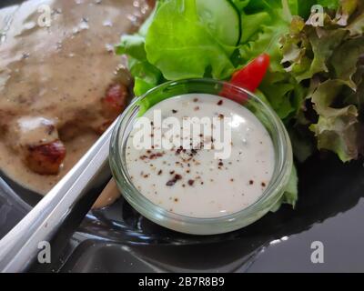 Das Salatdressing mit Avocado, Limette und Cilantro in einem Glasbecher Stockfoto