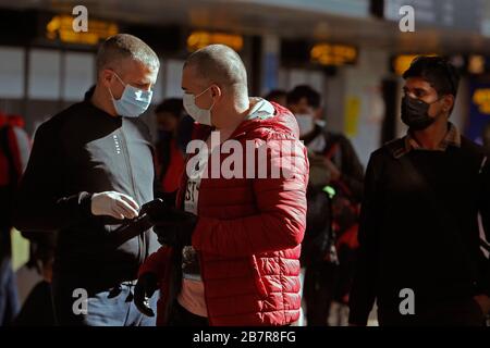 Bukarest, Rumänien. März 2020. Menschen, die Gesichtsmasken tragen, sind am internationalen Flughafen Henri Coanda in Bukarest, Rumänien, am 17. März 2020 zu sehen. Der rumänische Präsident Klaus Iohannis kündigte an, dass das Land ab dem 16. März in einen Notstaat eintreten wird, um sicherzustellen, dass die Regierung alle Mittel zur Bekämpfung der COVID-19-Epidemie einsetzt. Credit: Cristian Cristel/Xinhua/Alamy Live News Stockfoto