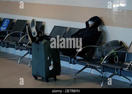 Bukarest, Rumänien. März 2020. Ein Mann, der eine Gesichtsmaske trägt, ruht auf dem internationalen Flughafen Henri Coanda in Bukarest, Rumänien, am 17. März 2020. Der rumänische Präsident Klaus Iohannis kündigte an, dass das Land ab dem 16. März in einen Notstaat eintreten wird, um sicherzustellen, dass die Regierung alle Mittel zur Bekämpfung der COVID-19-Epidemie einsetzt. Credit: Cristian Cristel/Xinhua/Alamy Live News Stockfoto