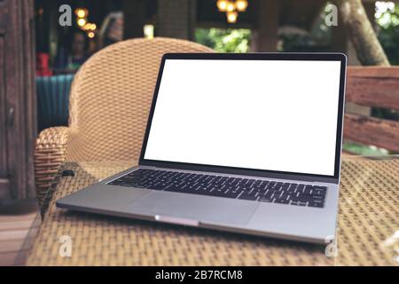 Mockup-Bild des Laptops mit leerem weißem Desktop-Bildschirm auf dem Tisch im Café Stockfoto