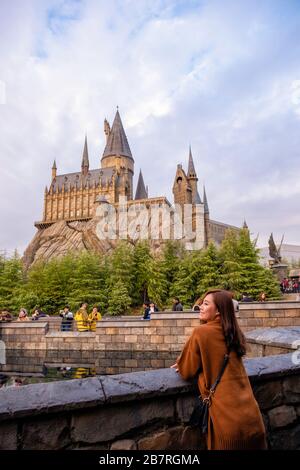 Dezember 2018: EINE schöne asiatin mit einem Harry Potter Schloss im Universal Japan im Hintergrund, Osaka Japan Stockfoto