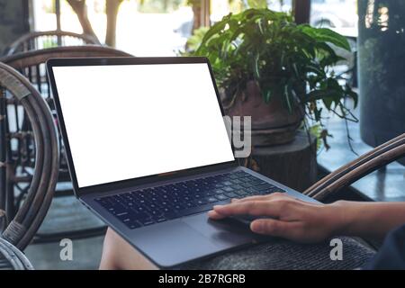 Verspottes Bild der Hände beim verwenden und Berühren des Notebook-Touchpads mit leerem weißem Desktop-Bildschirm, während Sie im Freien sitzen Stockfoto