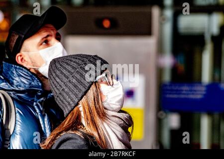 Reisende sahen das tragen von Gesichtsmasken als schützende Maßnahme vor dem Fangen des Covid-19 Coronavirus.mehrere Fluggesellschaften stornierten Flüge, da die internationale Reisenachfrage aufgrund des Ausbruchs des Covid-19 Coronavirus abnimmt. Mehrere europäische Länder haben Grenzen, Schulen sowie öffentliche Einrichtungen geschlossen und die meisten wichtigen Sport- und Unterhaltungsveranstaltungen abgesagt, um die Verbreitung des tödlichen Virus zu verhindern. Stockfoto