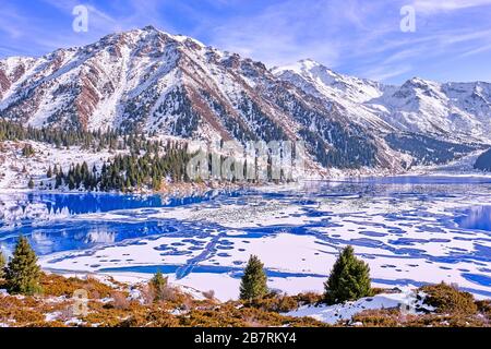 Herbst gibt Weg für Winter, Lufttemperatur sinkt und das Wasser in den See beginnt zu frieren. Textur und Muster von Eis auf dem ruhigen Wasser Oberfläche Stockfoto