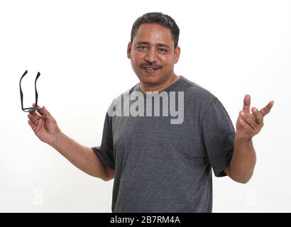 Ein lächelnder Indianermann, der in einem Studio Spektakel vor weißem Hintergrund hält Stockfoto