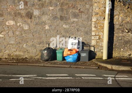 Eine Reihe von Binde- und Warnstreifen außerhalb der Bordsteinsammlung der verschiedenen Fahrzeuge, die alle verschiedenen Gegenstände sammeln sollen. Stockfoto