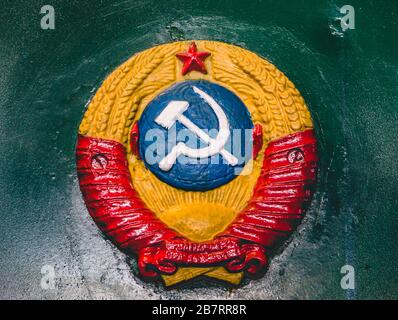 Altes retro-ehemaliges Wappen der Sowjetunion an der Wand der Zugslok Stockfoto