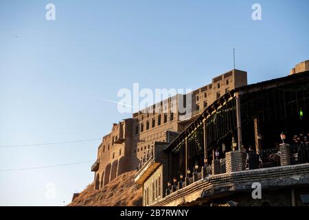 Irak, Iraq Kurdistan, Arbil, Erbil. Blick von einem Café auf die Straße im ersten Stock. Im Hintergrund steht die Zitadelle Erbil Qalat bei Sonnenuntergang. Stockfoto