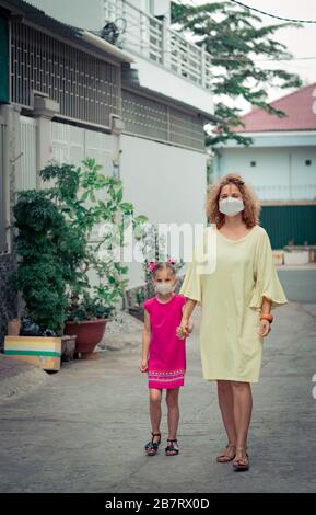 Frau und Tochter tragen eine Einwegmaske, um Virusinfektionen zu vermeiden. Schutz vor Coronavirus Stockfoto