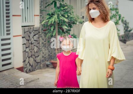 Frau und Tochter tragen eine Einwegmaske, um Virusinfektionen zu vermeiden. Schutz vor Coronavirus Stockfoto