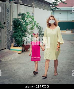 Frau und Tochter tragen eine Einwegmaske, um Virusinfektionen zu vermeiden. Schutz vor Coronavirus Stockfoto