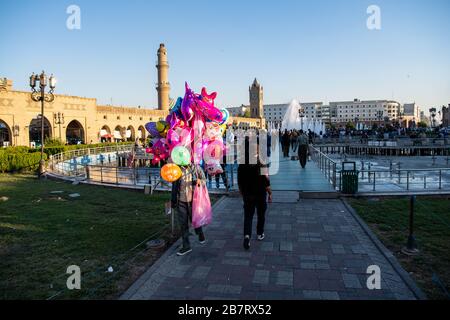 Irak, Iraq Kurdistan, Arbil, Erbil. Auf dem Park Shar spazieren ein Mann mit Balkons. Im Hintergrund steht Erbil Uhr. Stockfoto