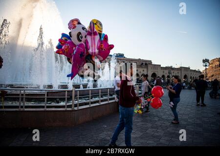 Irak, Iraq Kurdistan, Arbil, Erbil. Auf dem Parkschar verkauft ein Mann Ballons. Im Hintergrund ein Brunnen. Stockfoto