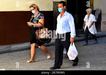 (200318) -- HAVANNA, 18. März 2020 (Xinhua) -- Fußgänger, die Gesichtsmasken tragen, gehen auf einer Straße in Havanna, Kuba, 17. März 2020. Ein Kreuzfahrtschiff mit fünf britischen Passagieren, die positiv auf COVID-19 getestet wurden, hat die kubanischen Territorialgewässer erreicht, sagte José Antonio Fernández, stellvertretender Leiter der Kommunikation im Außenministerium am Dienstag. Die betroffenen Passagiere sollen auf vier Charterflügen von British Airlines in ihr Land zurückgeflogen werden. Kuba stimmte einer Anfrage der britischen Regierung zu, dem Kreuzfahrtschiff MS Braemar zu ermöglichen, nach dem Andocken auf der Insel anzudocken Stockfoto