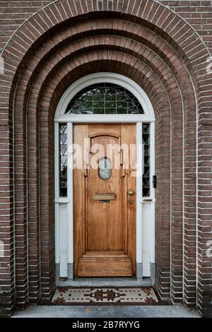 Naarden, Niederlande - 7. Juli 2019: Traditionelle schwarze Tür an einer Ziegelmauer in der mittelalterlichen Zitadelle Stockfoto