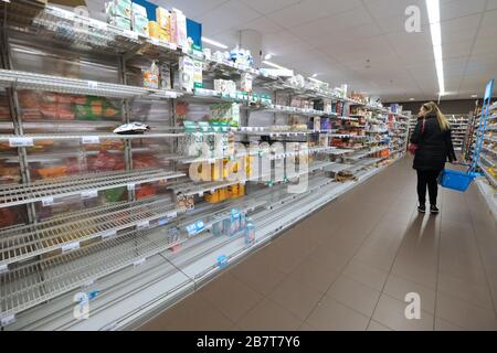 Eine Frau läuft am 16. März 2020 in den Haag, Niederlande, an leeren Regalen in einem Supermarkt vorbei. Kredit: Yuriko Nakao/AFLO/Alamy Live News Stockfoto