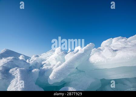 Naheis, das mit weißem Schnee bedeckt ist. Das Wasser im See wurde während der Winterzeit gefroren. Baikalsee, Russland Stockfoto