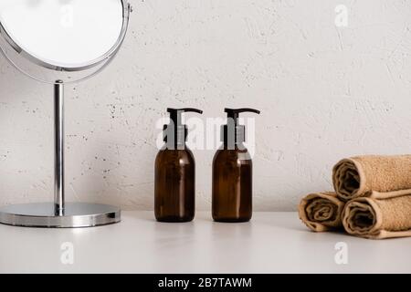 Runder Spiegel, Dispenser eco Body Creme und Handtücher auf weißem Hintergrund, Zero Waste Konzept Stockfoto