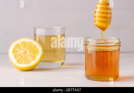 Honigbecher, Topf, Tee, Zitrone, Holzlöffel. Gesundheit. Immunität. Isoliert. Stockfoto