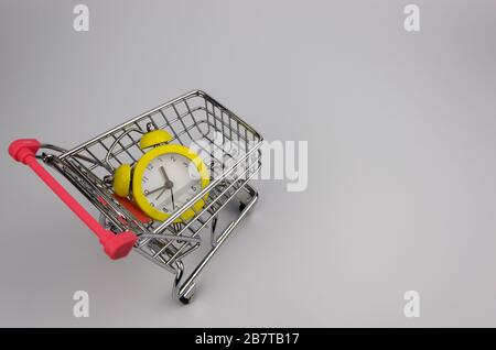 Gelber Wecker in einem Einkaufswagen Stockfoto