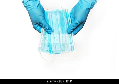 Hände in medizinischen Handschuhen mit Gesichtsschutzmasken, isoliert auf weißem Hintergrund. Schutzkonzept für Coronavirus Stockfoto
