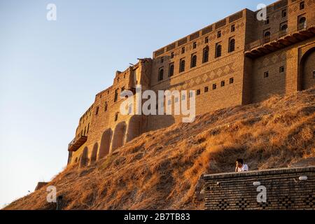 Irak, Iraq Kurdistan, Arbil, Erbil. Blick von einem Café auf die Straße im ersten Stock. Im Hintergrund steht die Zitadelle Erbil Qalat bei Sonnenuntergang. Stockfoto