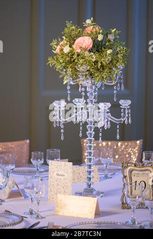 Elegante Tischanordnung für eine formelle Veranstaltung, eine Hochzeit oder ein feines Dining-Erlebnis, mit einem herrlichen Herzstück, einem Kristall-Kerzenständer Stockfoto