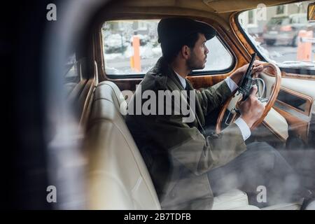 Selektive Fokussierung der Gangster, die Waffe und Lenkrad im Auto halten Stockfoto