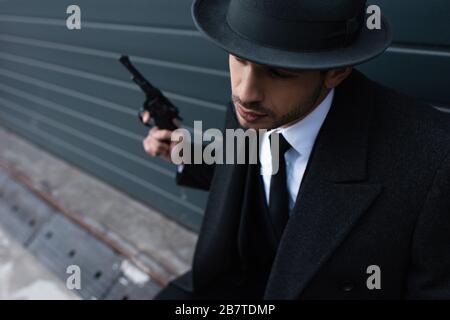 Selektive Fokussierung der Gangster, die Revolver in der Nähe der Mauer auf der Straße halten Stockfoto