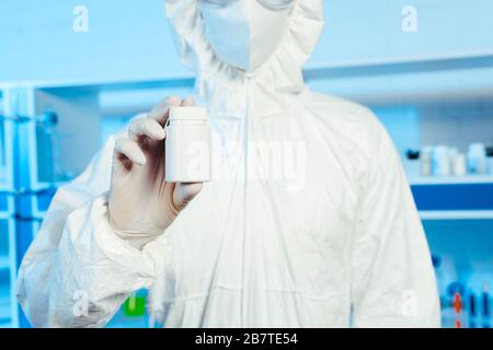 3/4-Ansicht des Wissenschaftlers im Haselmattenanzug, der die Flasche im Labor hält Stockfoto