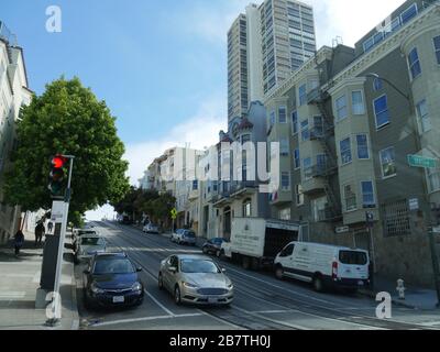San Francisco, Kalifornien - Juli 2018: Abschüssige Straße mit Gebäuden und Autos, die an der Bordsteinkante in San Francisco geparkt sind. Stockfoto