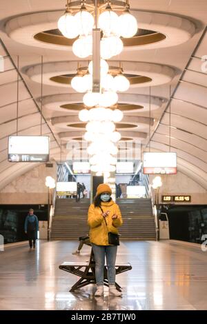 Die junge europäerin in schützender, medizinischer Gesichtsmaske mit Antiseptikum in der U-Bahn. Neues Coronavirus (COVID-19). Konzept des Gesundheitsautos Stockfoto