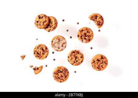 Schokoladenchip-Plätzchen, die auf weißem Hintergrund fliegen, werden von oben geschossen Stockfoto