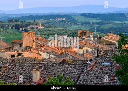 Dächer von San Gimignano, toskanische Landschaft mit sanften Hügeln und Santa Maria Assunta a Monte Oliveto Minore aus Parco della Rocca, San Gimignano. Stockfoto