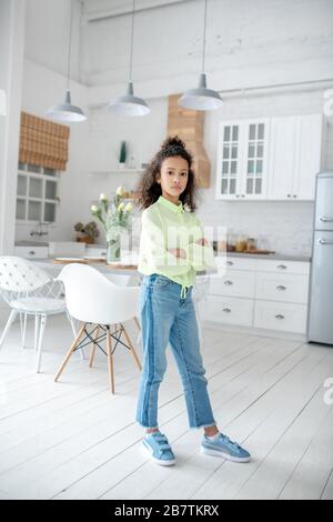 Geschweifte Mädchen mit in Jeans stehend mit gekreuzten Armen Stockfoto