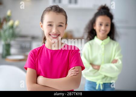 Zwei Mädchen stehen in der Küche und sehen glücklich aus Stockfoto