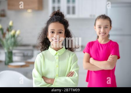 Zwei Mädchen stehen in der Küche und lächeln Stockfoto