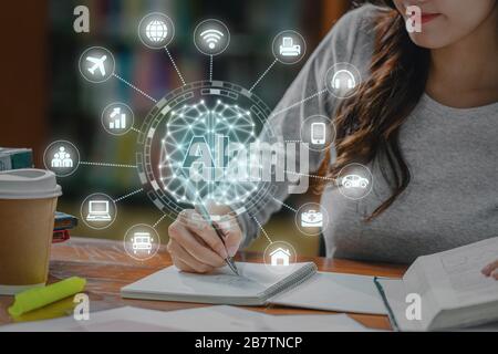 Polygonale Gehirnform einer künstlichen Intelligenz mit verschiedenen Ikone der Smart City Internet of Things Technology gegenüber Asian Young Student Hand Writin Stockfoto