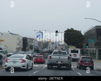 San Francisco, Kalifornien - Juli 2018: Langsamer Spätnachmittags-Verkehr an einem nebligen Tag in der Lincoln Street, San Francisco. Stockfoto