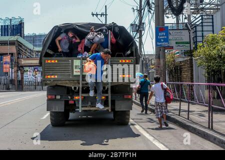 Makati City. März 2020. Die Menschen steigen aus einem Militärlastwagen aus, der den gestrandeten Pendlern kostenlose Fahrten anbietet, nachdem die philippinische Regierung die Einstellung öffentlicher Massenverkehrseinrichtungen gemäß der "erweiterten Quarantäne der Gemeinde" in Makati City, den Philippinen am 18. März 2020 angeordnet hat. Credit: Rouelle Umali/Xinhua/Alamy Live News Stockfoto