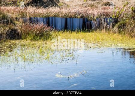 Kunststoff-Staudamm blockte früher eine Wasserrinne und verhinderte so die Erosion im Rahmen der Moorsanierung. Kinder Scout, Derbyshire, Peak District, England, Großbritannien Stockfoto