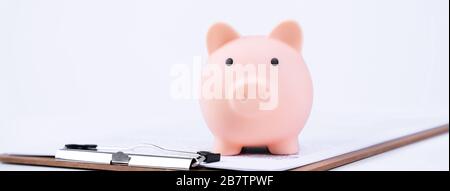 Geldeinlage - Einzahlungsbox, Piggy Bank, schönes Modell auf weißem Hintergrund, Geld sparen, um für Darlehen oder Versicherungen zu zahlen, Nahaufnahme, Kopierraum. Stockfoto