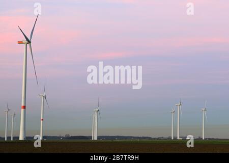 Windkraftanlagen, Windpark, Windpark, Windmühlen, Windkraft auf Ackerland, erneuerbare Energie mit verschmutzter Luft über dem Horizont, NRW, Deutschland. Stockfoto