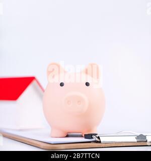 Geldeinlage - Einzahlungsbox, Piggy Bank, schönes Modell auf weißem Hintergrund, Geld sparen, um für Darlehen oder Versicherungen zu zahlen, Nahaufnahme, Kopierraum. Stockfoto
