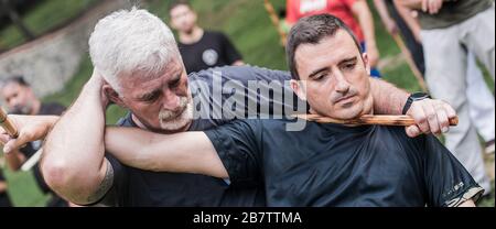 Filipino escrima arnis Instruktor und Student Practice Stick Fight Choke Techniken auf dem Kapap Martial Arts Seminar Stockfoto